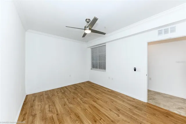 a view of empty room with wooden floor