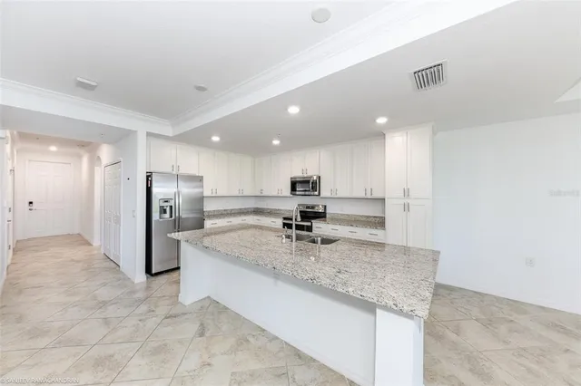 a large kitchen with granite countertop a sink and a stove top oven