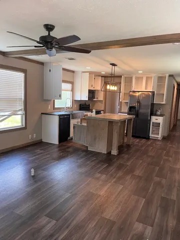 a view of a kitchen with furniture and wooden floor