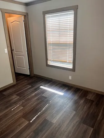 a view of a room with wooden floor and a window