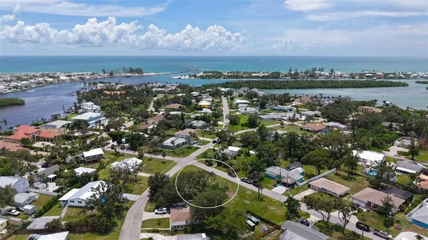 an aerial view of a city with lots of residential buildings ocean and mountain view in back