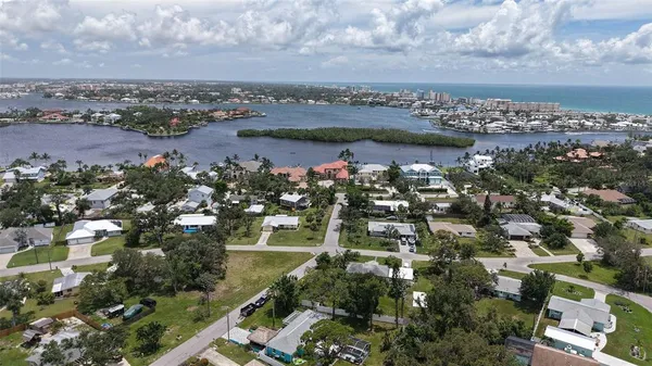 an aerial view of a city with lots of residential buildings ocean and mountain view in back