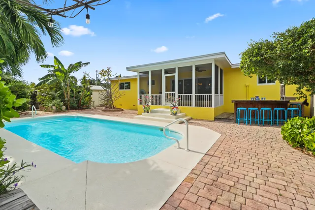 a view of a house with swimming pool and sitting area