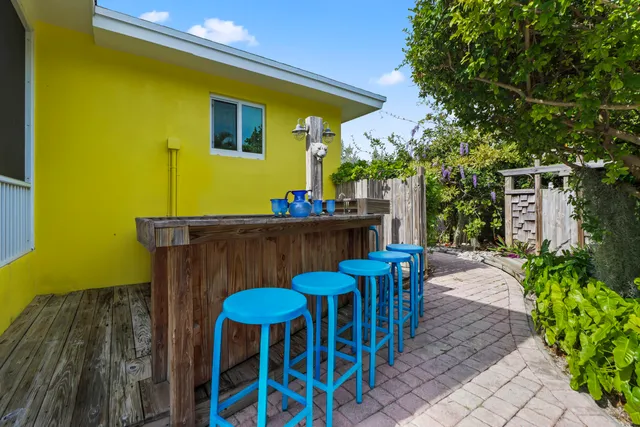 a view of a chairs and table in the patio with a wooden fence