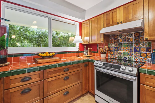 a kitchen with stainless steel appliances granite countertop a stove and a sink