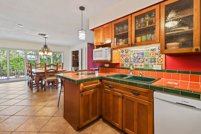 a kitchen with stainless steel appliances granite countertop a stove a sink and a dining table