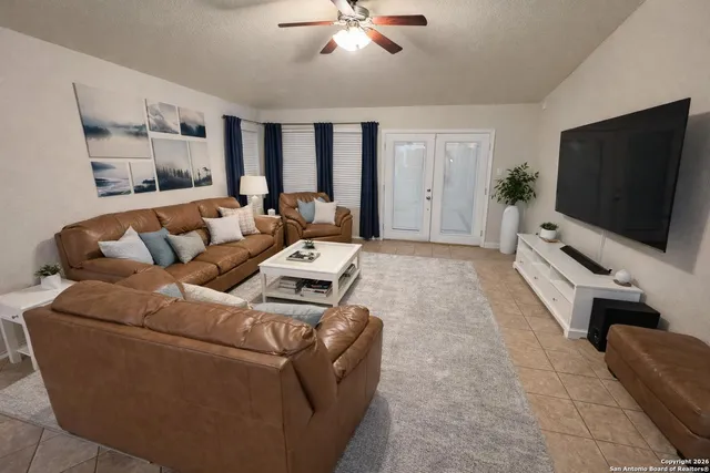 a view of a yard with large trees and wooden fence