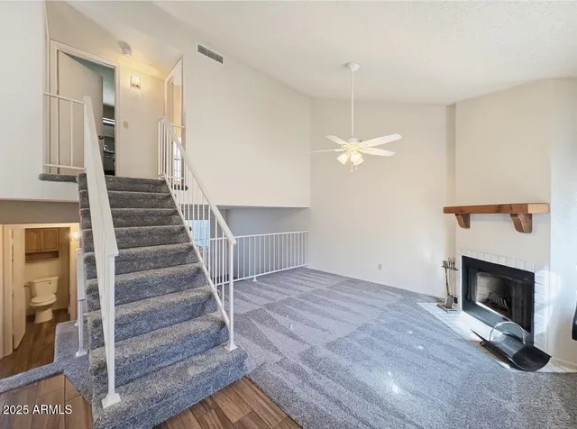 a view of a livingroom with wooden floor and a ceiling fan