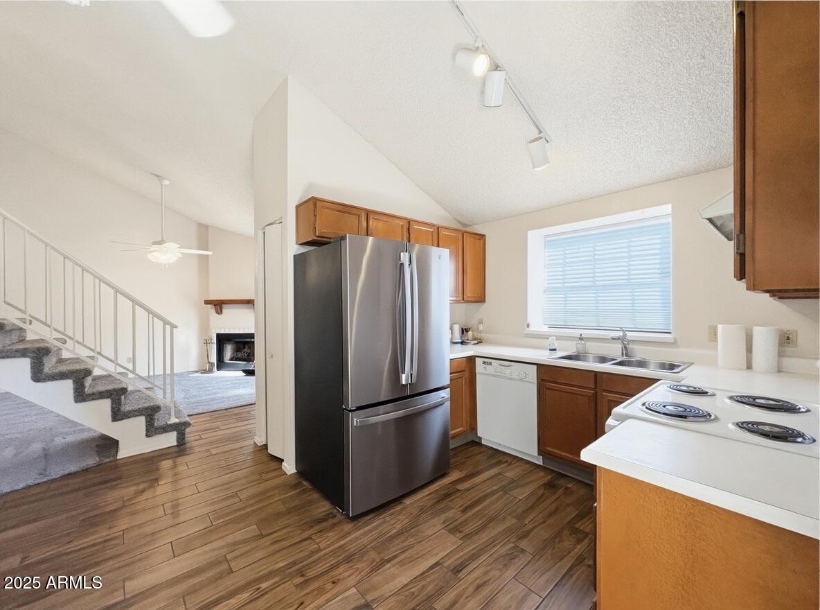 921 West University Drive, Unit 1010 Mesa, AZ 85201 - Photo 5 of 24 a kitchen with a refrigerator a stove top oven a sink and dishwasher with wooden floor