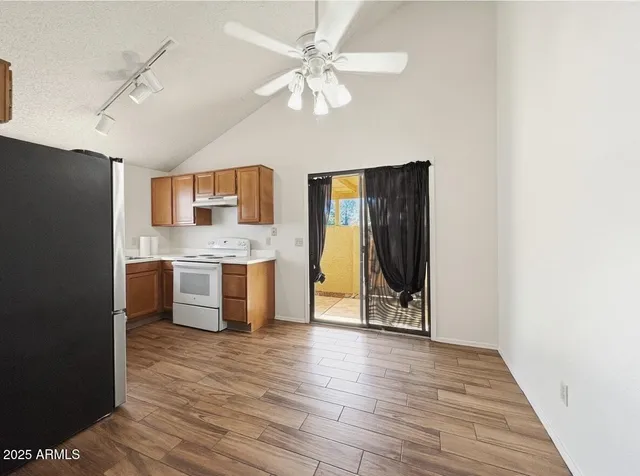 a view of a kitchen with a sink and a refrigerator