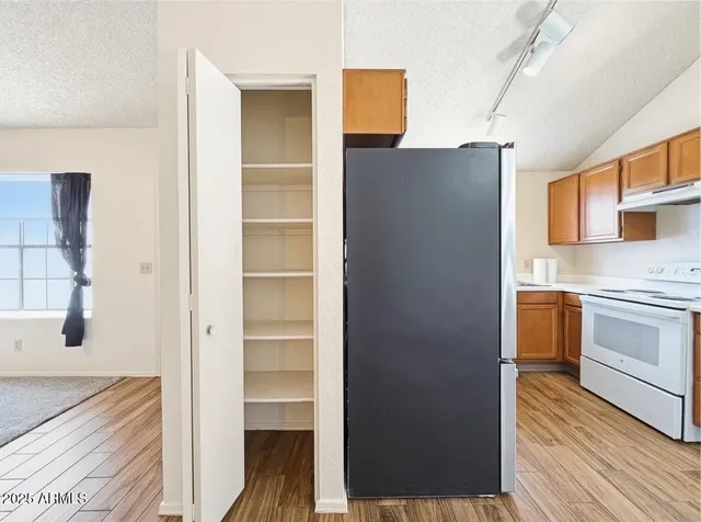 a kitchen with a refrigerator and a stove top oven