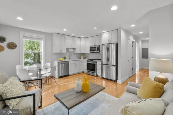 a kitchen with a refrigerator a couch and a dining table