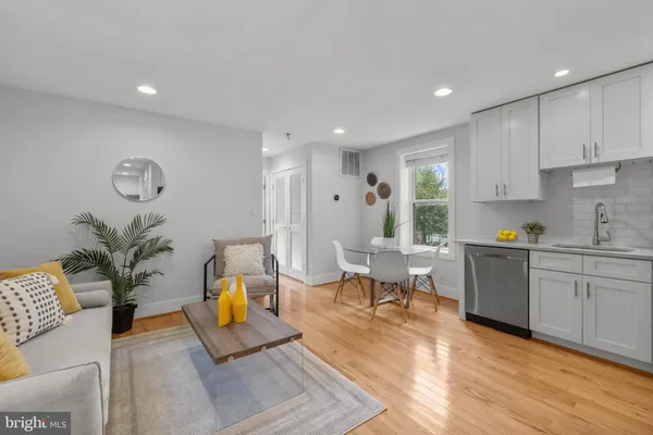 a living room with furniture kitchen view and a window