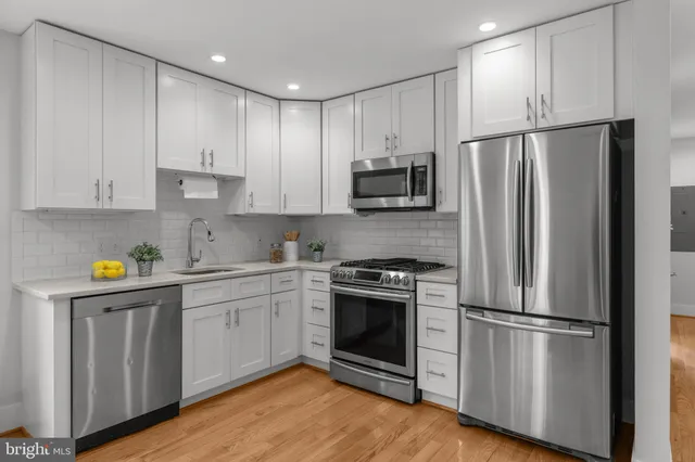 a kitchen with stainless steel appliances a refrigerator sink and microwave