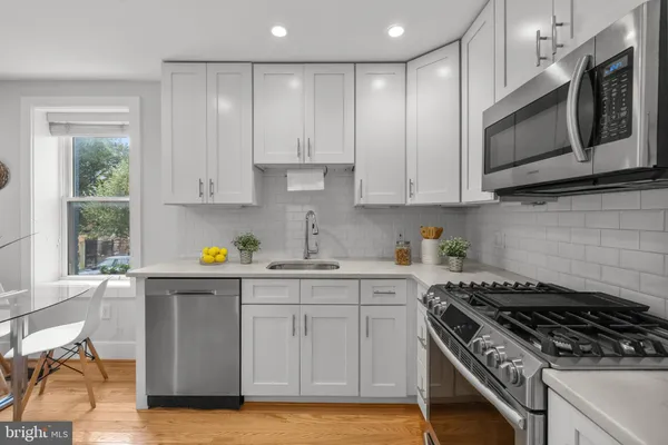 a kitchen with stainless steel appliances granite countertop a stove a sink and a microwave