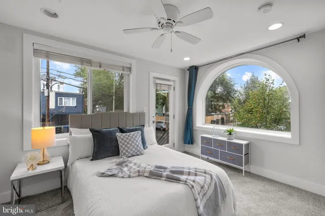 a bedroom with a bed and a large window