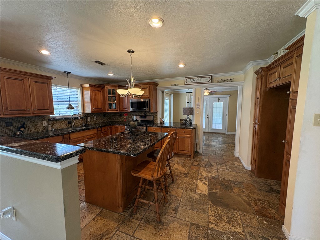 1501 Maple Drive Bryan, TX 77803 - Photo 5 of 19 a kitchen with kitchen island a stove a sink a refrigerator and a counter top space