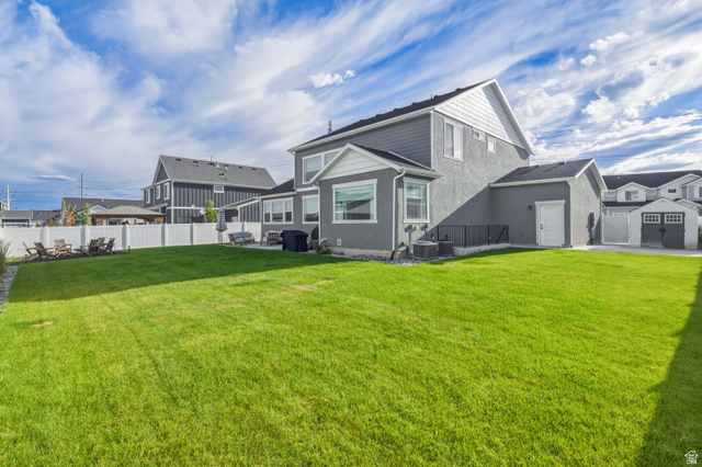 870 North Ada Loop Lehi, UT 84048 - Photo 46 of 51 Spacious backyard featuring a lush green lawn, white privacy fencing, and two built-in storage sheds