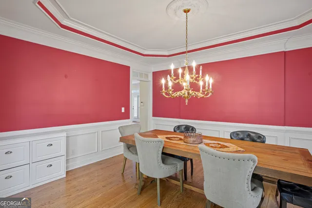 a dining room with furniture a chandelier and wooden floor