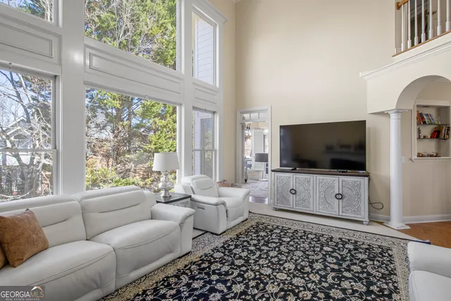 a living room with furniture a flat screen tv and a large window