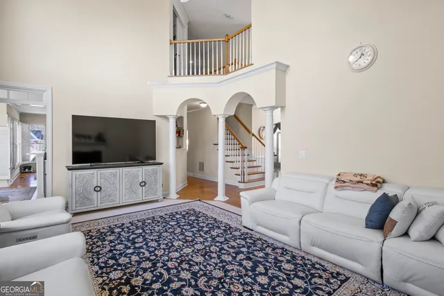 a living room with furniture a flat screen tv and a window