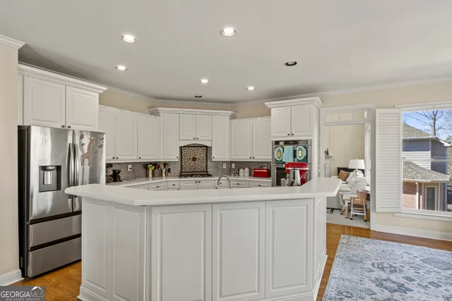 a kitchen with stainless steel appliances granite countertop a sink refrigerator and cabinets