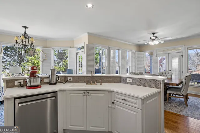 a kitchen with white cabinets and sink