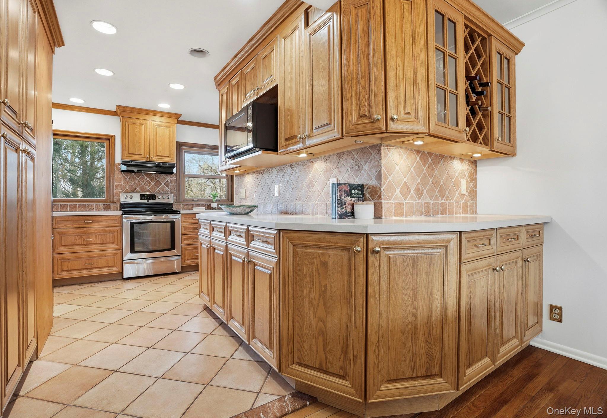 20 Highview Road Ossining, NY 10562 - Photo 12 of 28 Kitchen with electric stove, light countertops, crown molding, black microwave, and decorative backsplash