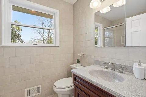 a bathroom with a sink a toilet and a mirror