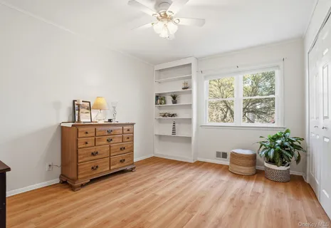 a view of a bedroom with wooden floor and cabinet