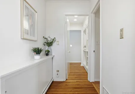 a view of a hallway with wooden floor and staircase