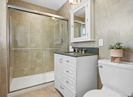 a bathroom with a granite countertop sink toilet and shower