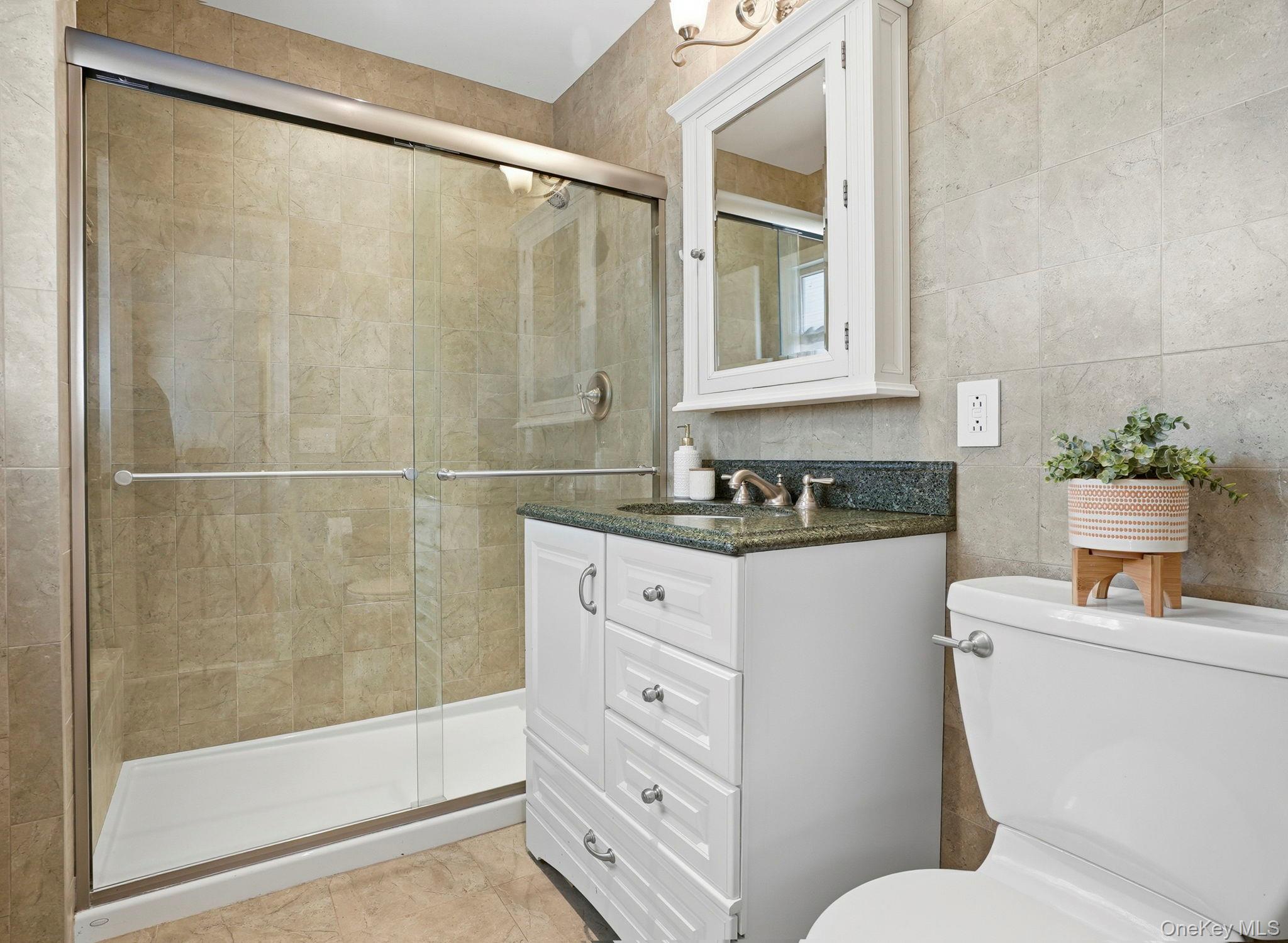 20 Highview Road Ossining, NY 10562 - Photo 20 of 28 Full Primary en-suite bathroom featuring vanity, a stall shower, and tile walls