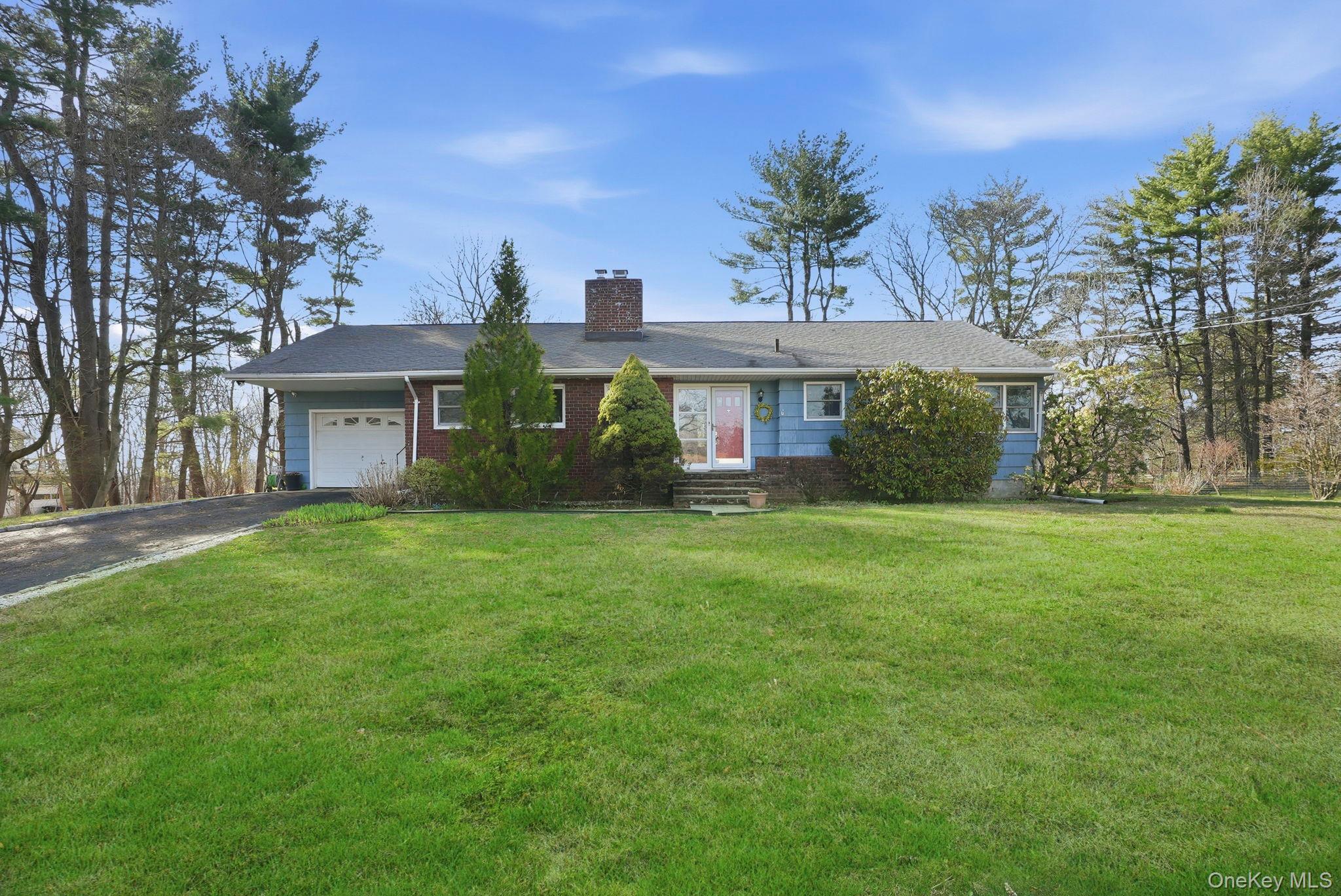 20 Highview Road Ossining, NY 10562 - Photo 2 of 28 Ranch-style home with a chimney, an attached garage, driveway, a front lawn, and brick siding