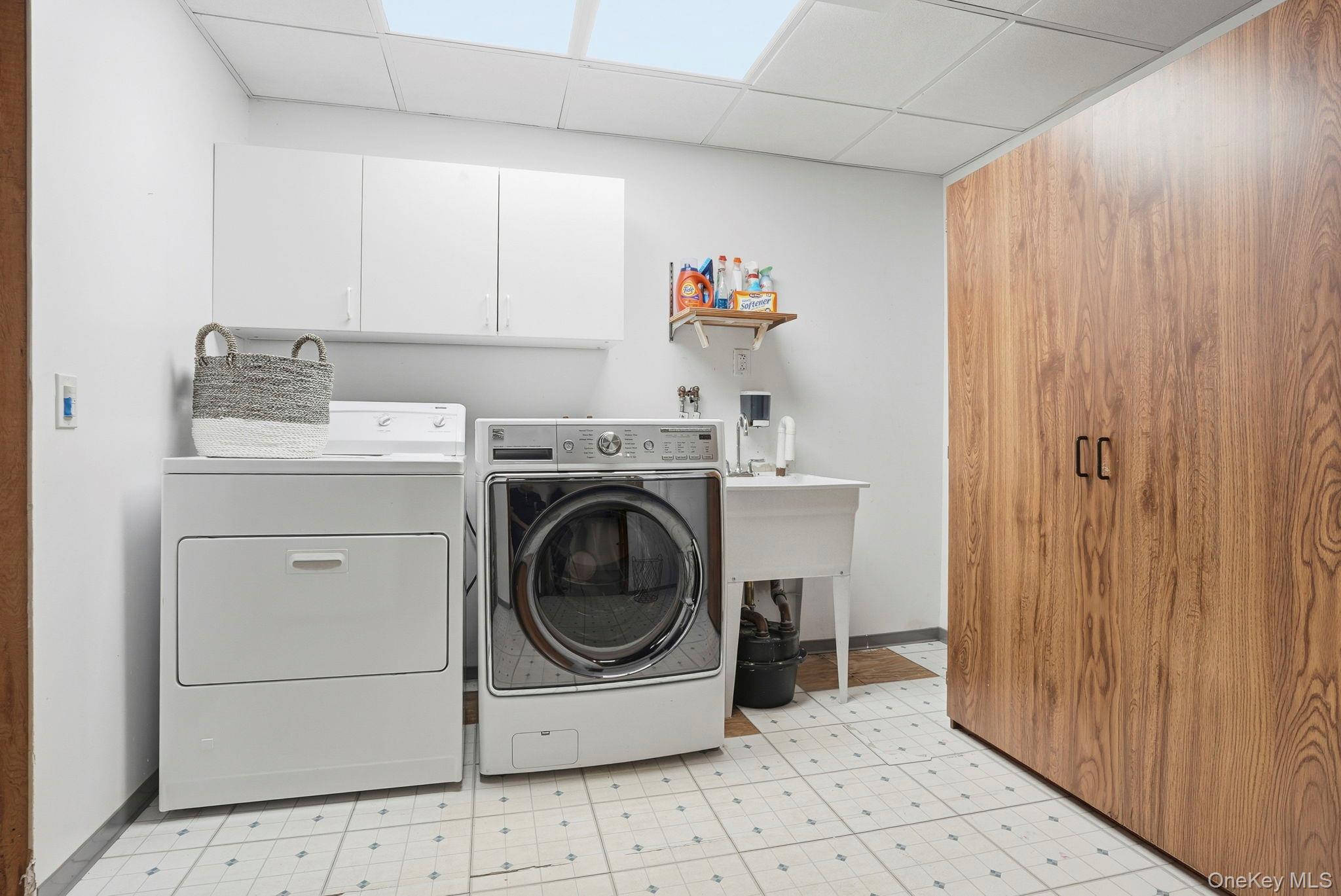 20 Highview Road Ossining, NY 10562 - Photo 22 of 28 Laundry space featuring light floors, a paneled ceiling, cabinet space, and separate washer and dryer and sink
