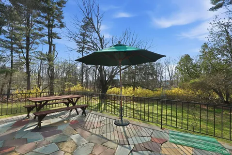 a view of a terrace with chairs and umbrella