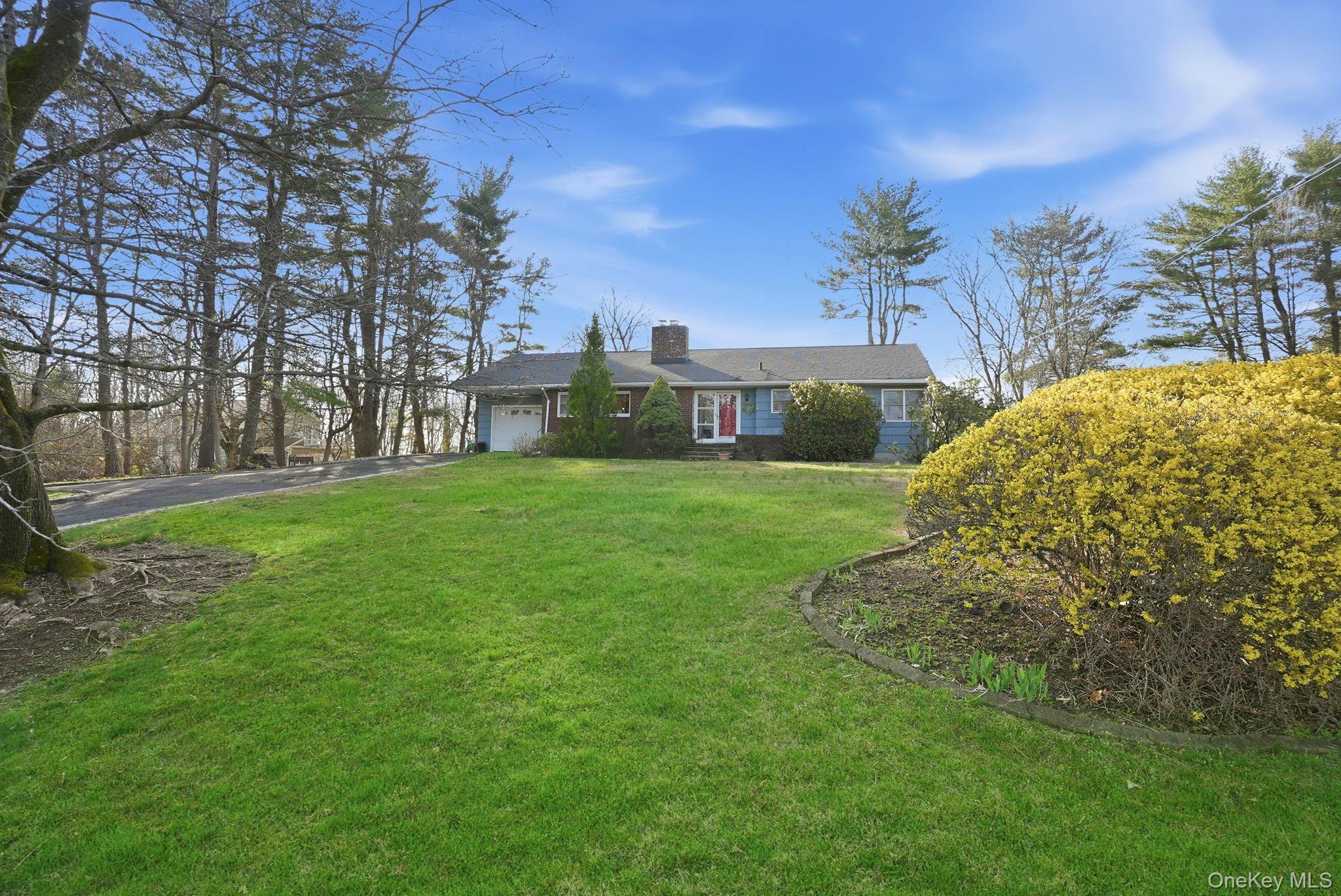 20 Highview Road Ossining, NY 10562 - Photo 3 of 28 View of front facade with a chimney, a garage, a front lawn, and driveway