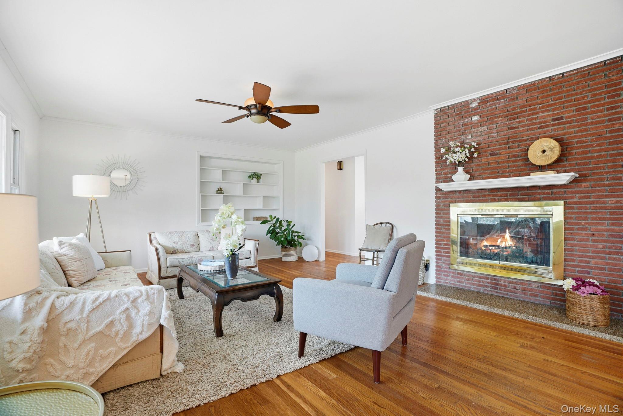 20 Highview Road Ossining, NY 10562 - Photo 5 of 28 Living area with built in shelves, ceiling fan, large bay window, and hardwood finished fireplace, and ornamental molding