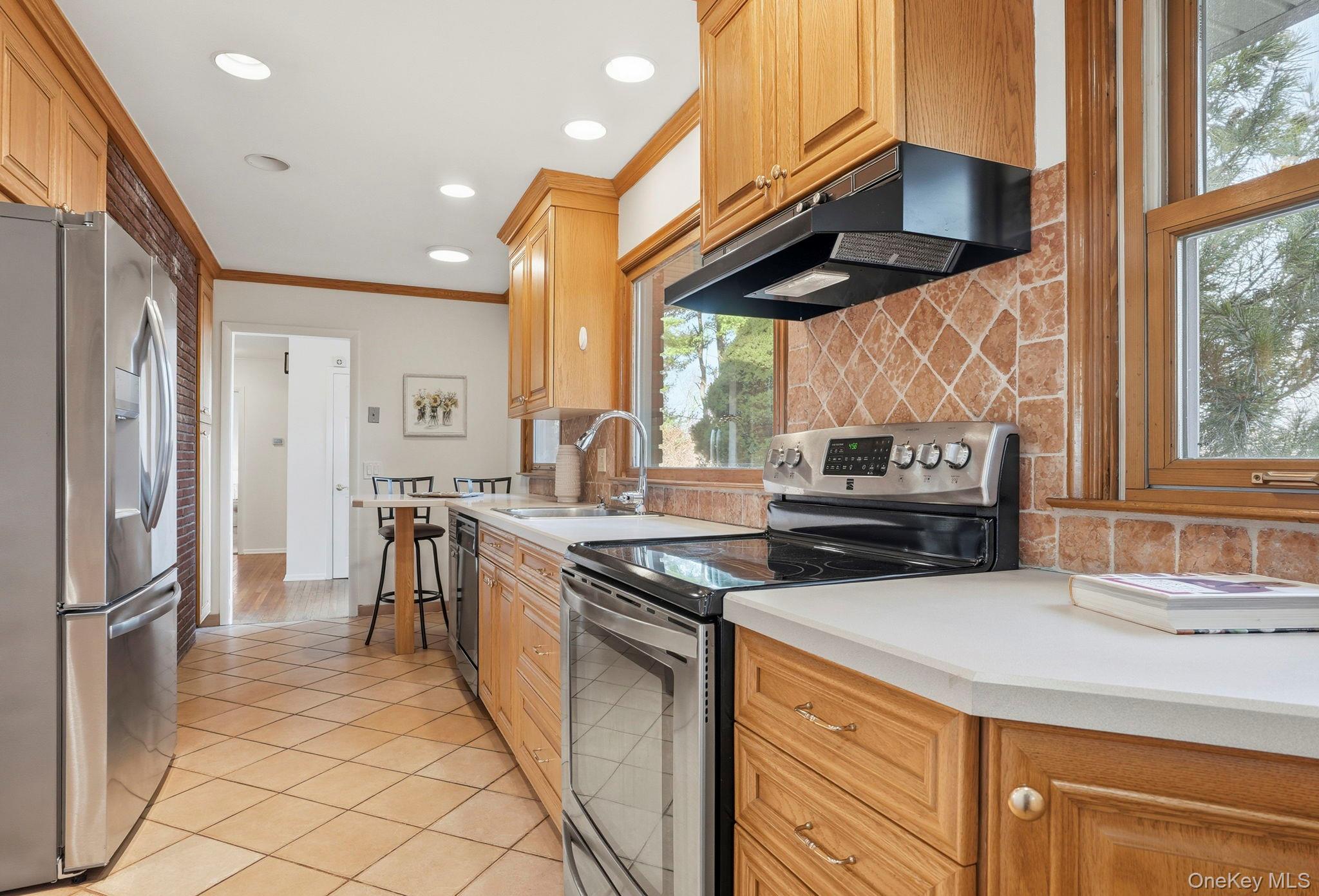 20 Highview Road Ossining, NY 10562 - Photo 10 of 28 Kitchen featuring stainless steel appliances, decorative backsplash, ornamental molding, light tile patterned flooring, and recessed lighting