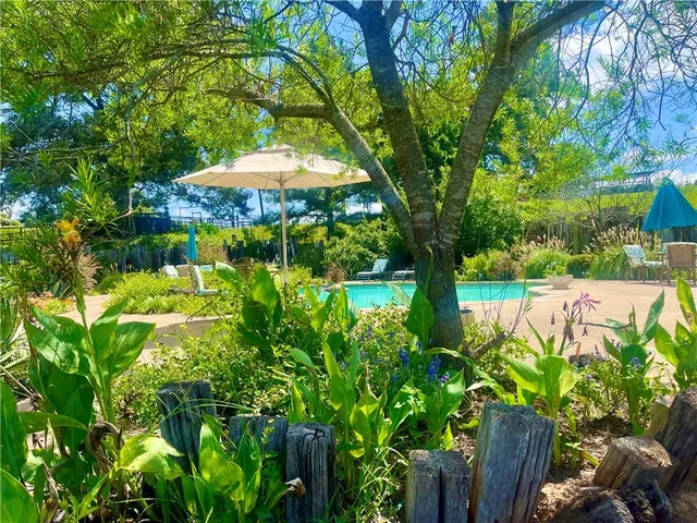 a backyard of a house with lots of green space and fountain