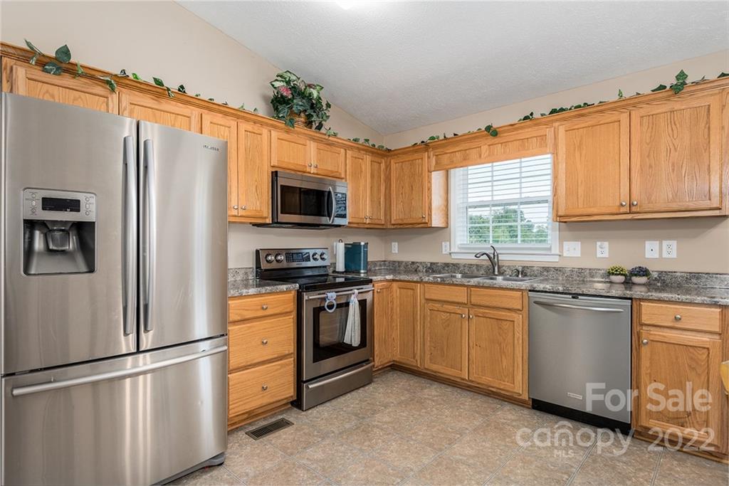 4226 Hickory Nut Ridge Road Hudson, NC 28638 - Photo 10 of 20 a kitchen with stainless steel appliances granite countertop a refrigerator stove microwave and sink