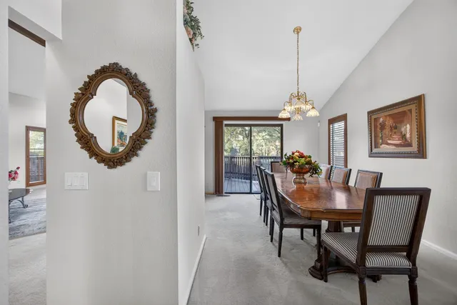 a view of a dining room with furniture and a chandelier