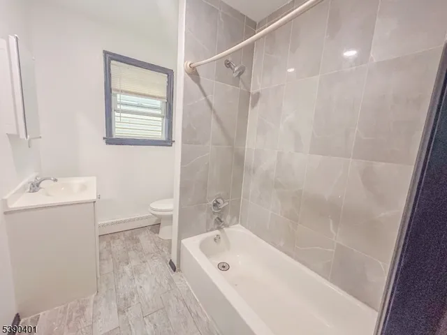 a bathroom with a tub a sink and a large mirror