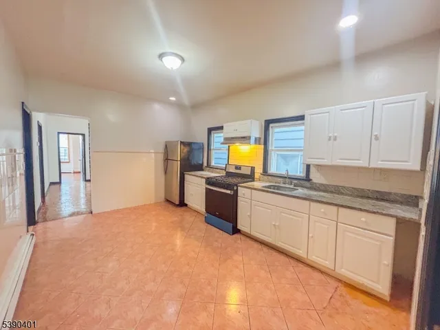 a large kitchen with cabinets and stainless steel appliances