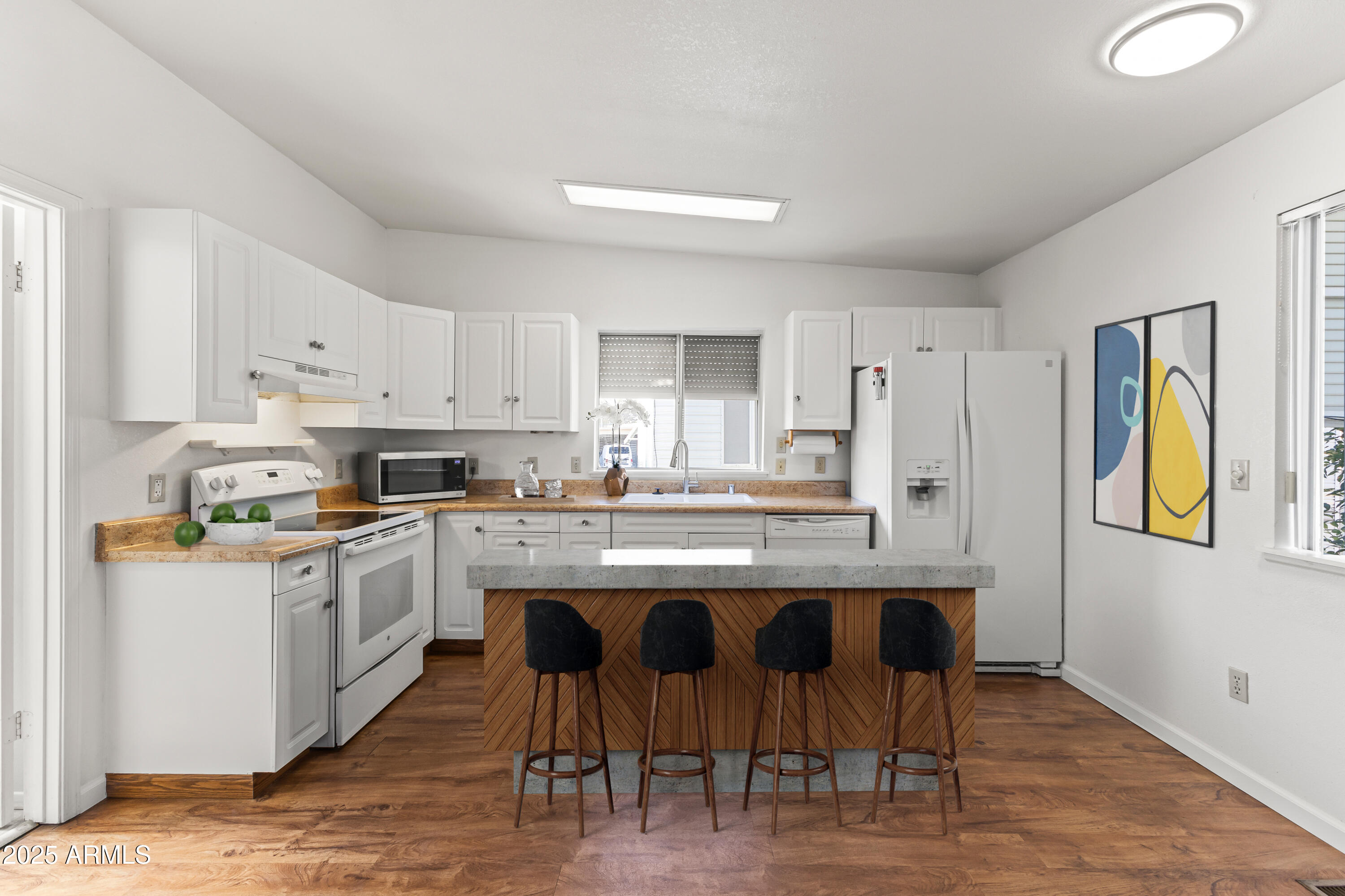 17200 West Bell Road, Unit 771 Surprise, AZ 85374 - Photo 18 of 37 a kitchen with stainless steel appliances granite countertop a table chairs sink refrigerator and cabinets