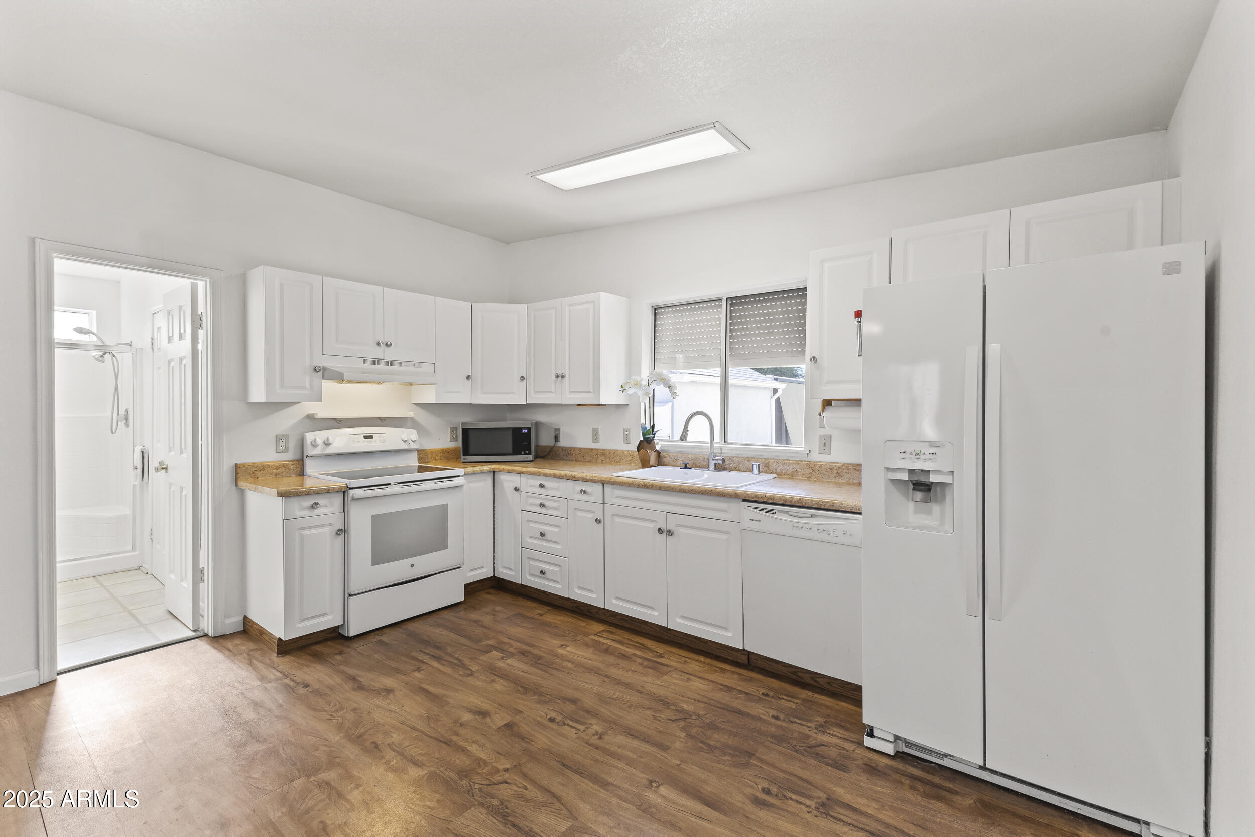 17200 West Bell Road, Unit 771 Surprise, AZ 85374 - Photo 21 of 37 a kitchen with white cabinets and white appliances