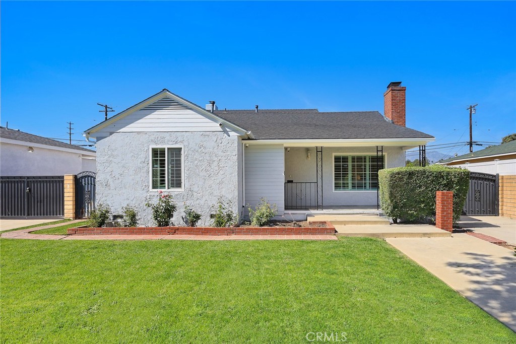 a front view of a house with a yard and trees