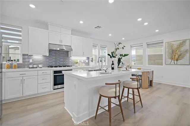a kitchen with kitchen island a stove a table and chairs in it