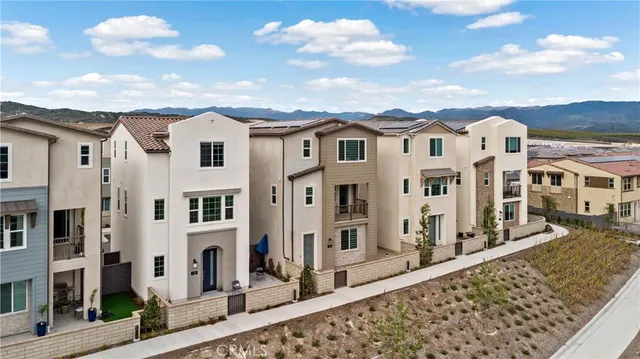 a view of a white building among the street with palm trees