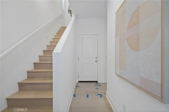 a view of staircase with white walls and white door